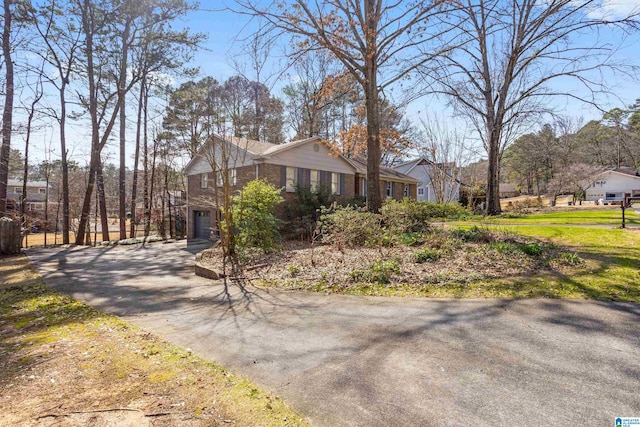 view of front of property featuring driveway, a garage, and brick siding