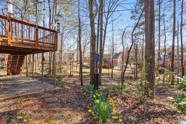 view of yard featuring a patio area, stairway, and a wooden deck