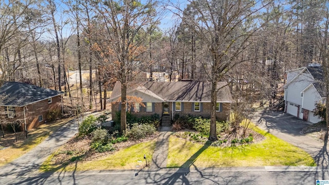 view of front facade with aphalt driveway, brick siding, and a garage