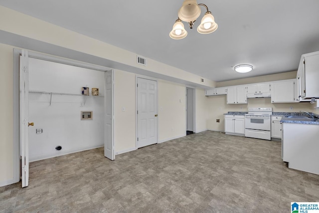 kitchen featuring electric range, sink, and white cabinetry