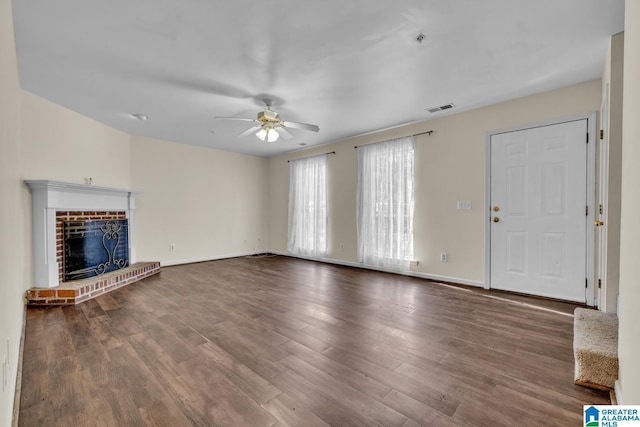 unfurnished living room featuring ceiling fan, a brick fireplace, and hardwood / wood-style flooring