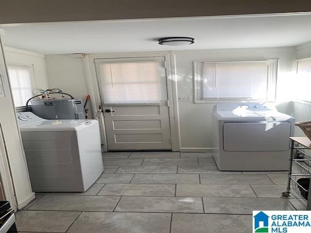 clothes washing area featuring washing machine and clothes dryer and electric water heater