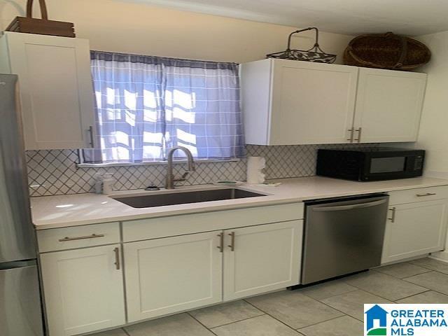 kitchen featuring sink, white cabinets, stainless steel appliances, and tasteful backsplash