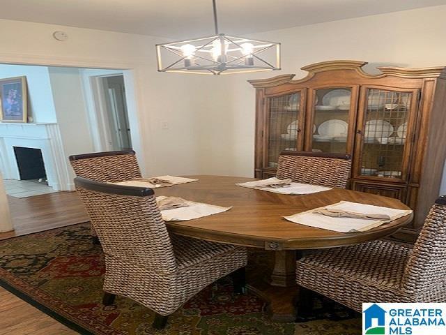 dining room featuring wood-type flooring and an inviting chandelier