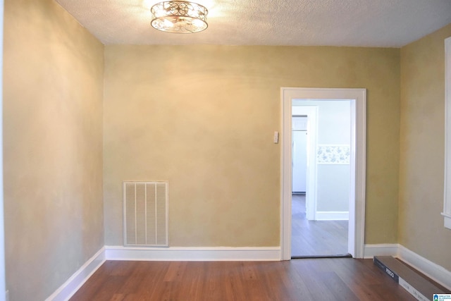 spare room with hardwood / wood-style floors and a textured ceiling