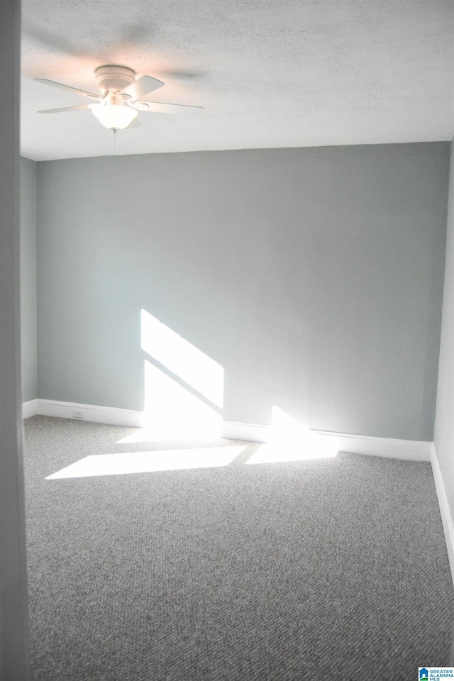 carpeted spare room featuring ceiling fan and a textured ceiling