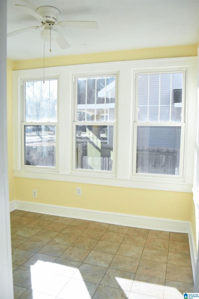 unfurnished sunroom with ceiling fan