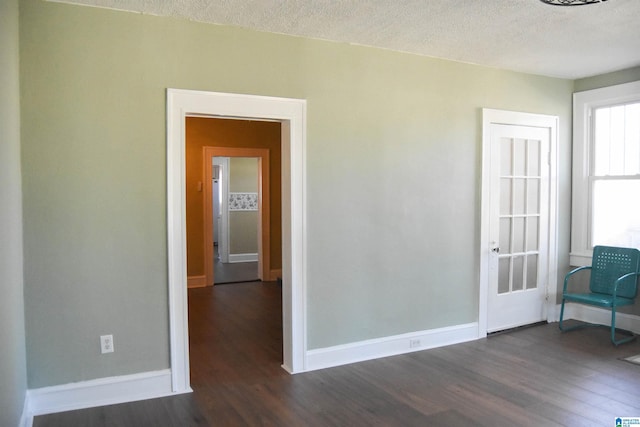 unfurnished room featuring a textured ceiling and dark hardwood / wood-style flooring