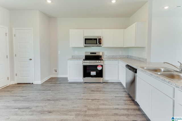 kitchen featuring sink, white cabinetry, appliances with stainless steel finishes, and light hardwood / wood-style flooring