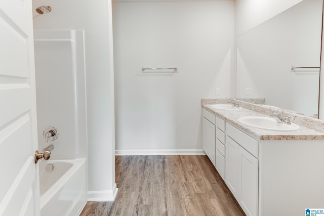 bathroom featuring wood-type flooring, shower / tub combination, and vanity