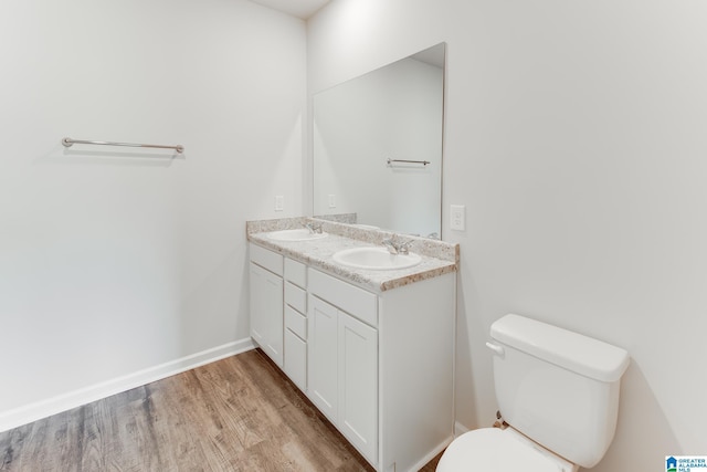 bathroom with toilet, vanity, and hardwood / wood-style floors