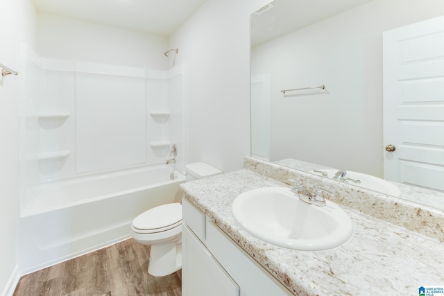 full bathroom with hardwood / wood-style flooring, shower / tub combination, toilet, and vanity