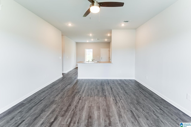 unfurnished living room with ceiling fan, dark wood-type flooring, and sink