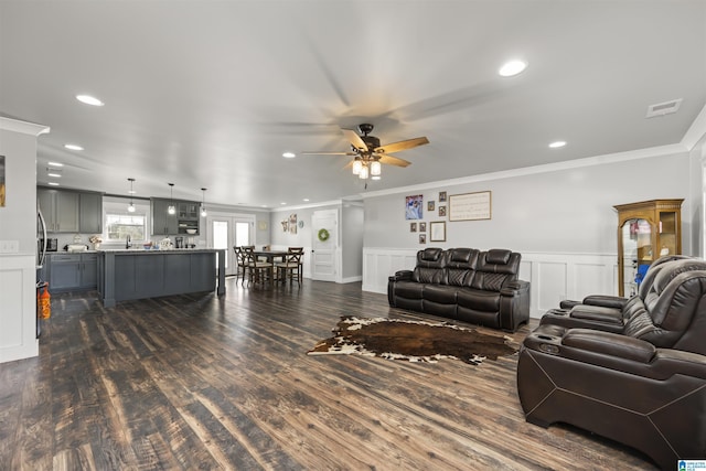 living room with ceiling fan, dark hardwood / wood-style flooring, and ornamental molding