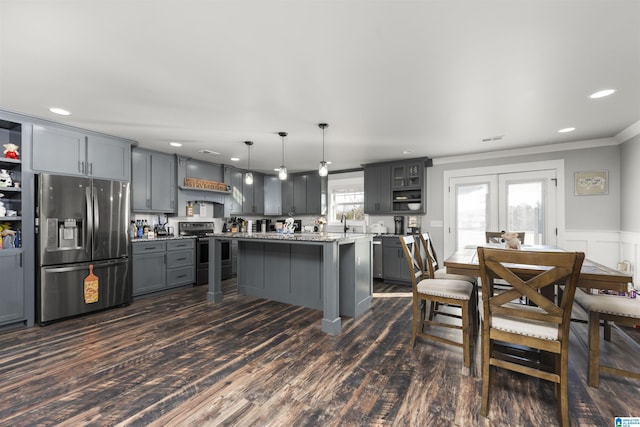 kitchen featuring hanging light fixtures, dark hardwood / wood-style floors, gray cabinets, and stainless steel appliances