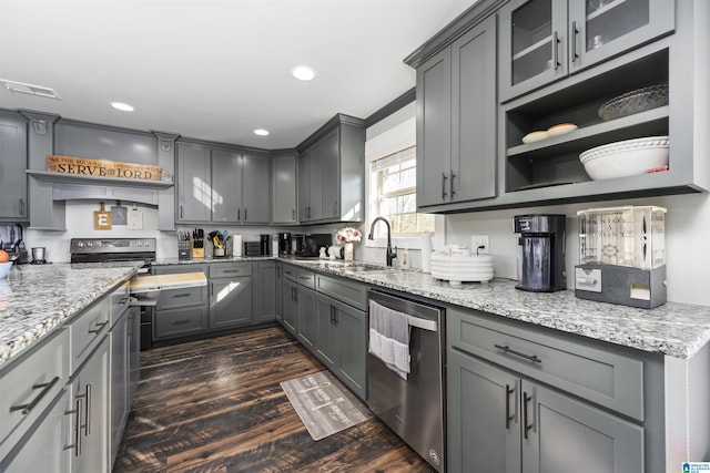 kitchen featuring light stone countertops, dark wood-type flooring, stainless steel appliances, sink, and gray cabinetry