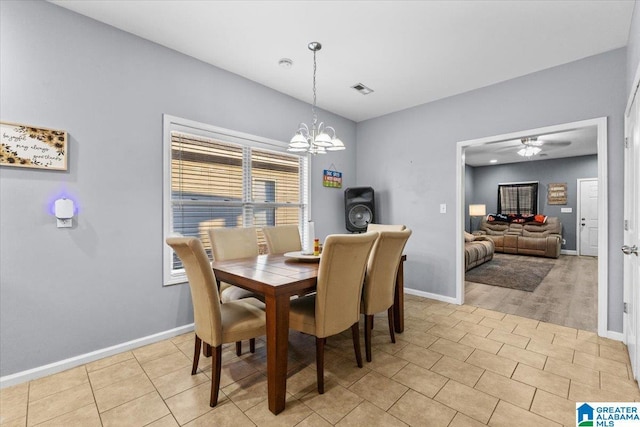 tiled dining room with ceiling fan with notable chandelier