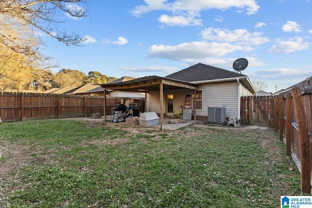 back of house with central air condition unit, a patio area, and a lawn