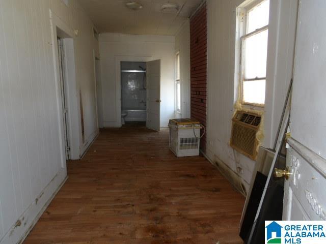 corridor featuring dark wood-type flooring, cooling unit, and a healthy amount of sunlight