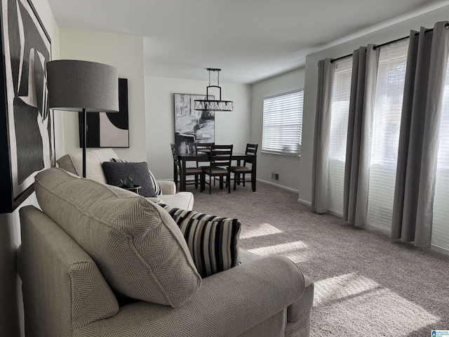 living area with carpet floors, visible vents, and baseboards