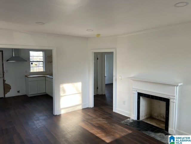 unfurnished living room featuring dark wood-type flooring and a tiled fireplace