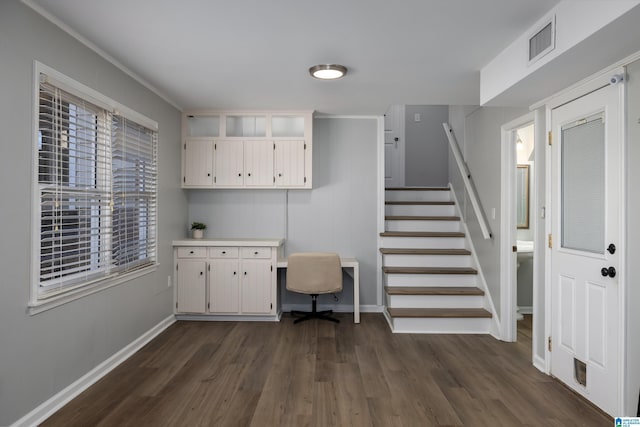 interior space featuring built in desk, dark hardwood / wood-style floors, and crown molding