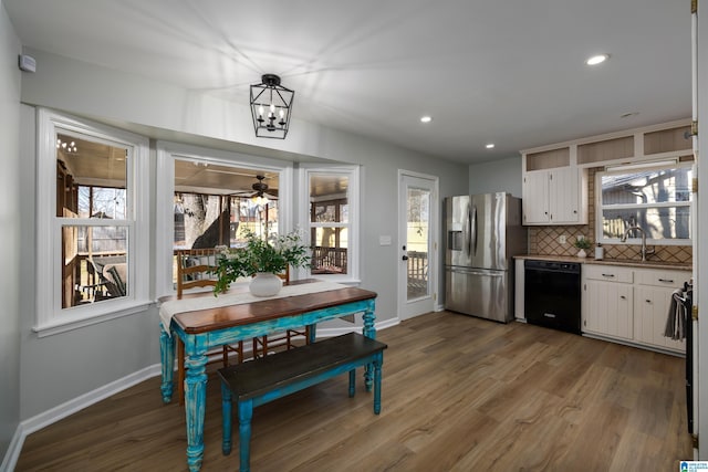 kitchen featuring white cabinetry, stainless steel fridge, black dishwasher, and tasteful backsplash