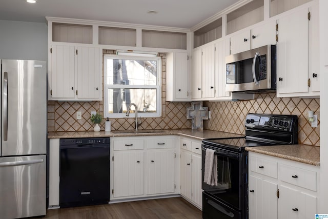 kitchen featuring sink, backsplash, white cabinets, and black appliances