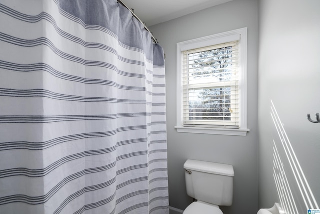 bathroom featuring a wealth of natural light, toilet, and a shower with shower curtain