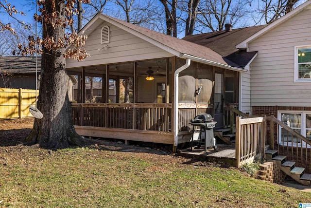 rear view of house with a sunroom and a yard