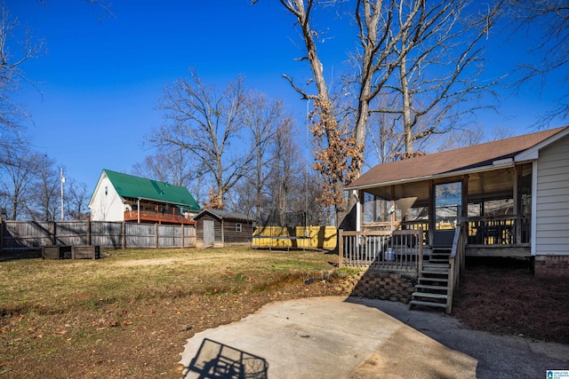 view of yard with a trampoline, a patio area, a shed, and a wooden deck