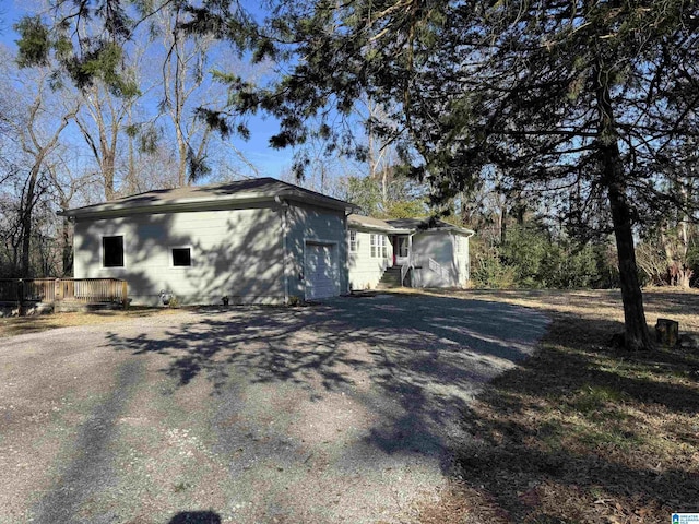 view of property exterior featuring a garage and a deck