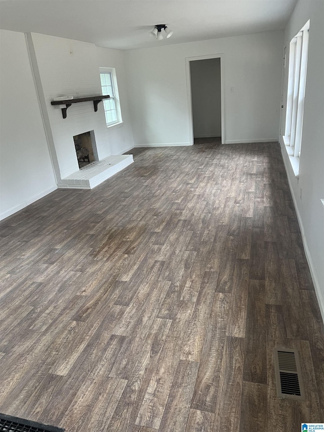 unfurnished living room with a fireplace and dark hardwood / wood-style floors