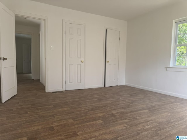 unfurnished bedroom with dark hardwood / wood-style flooring