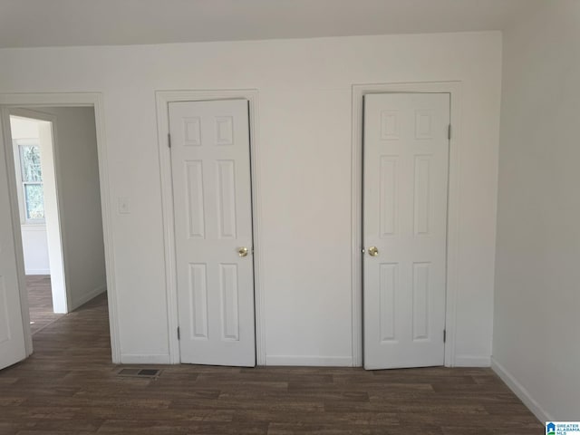 unfurnished bedroom featuring dark hardwood / wood-style flooring