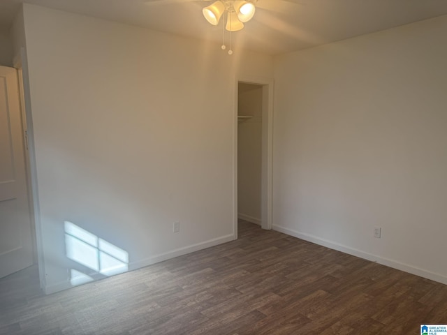 empty room featuring dark wood-type flooring and ceiling fan