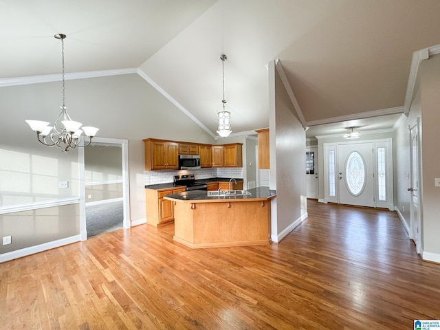 kitchen with kitchen peninsula, stainless steel appliances, decorative backsplash, a chandelier, and a breakfast bar