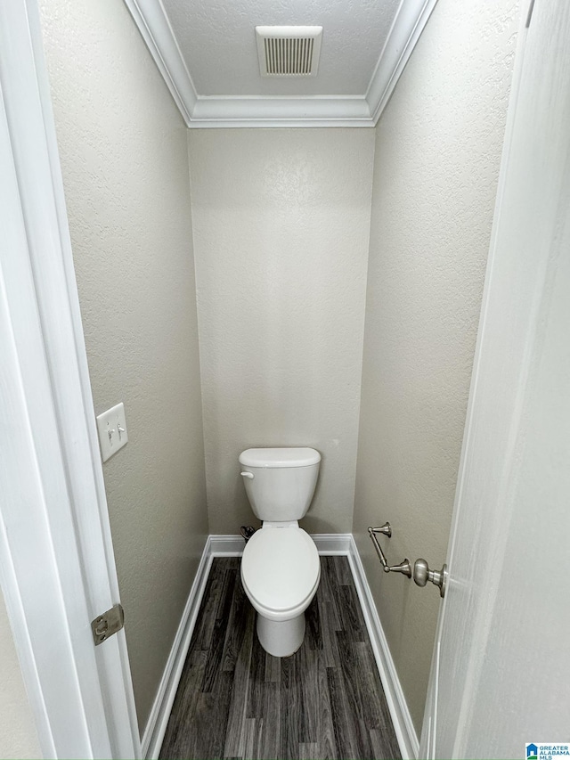 bathroom featuring wood-type flooring, toilet, crown molding, and a textured ceiling