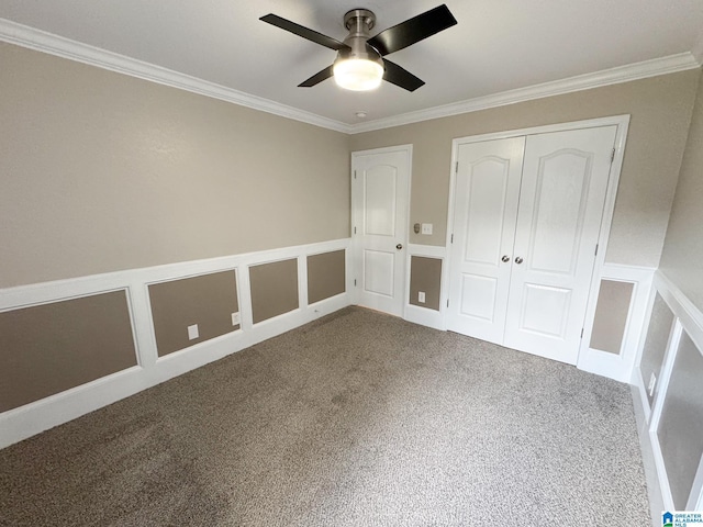 unfurnished bedroom with ceiling fan, a closet, ornamental molding, and carpet flooring