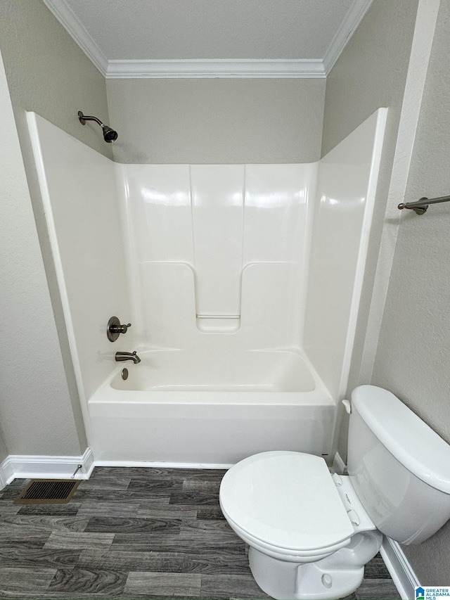 bathroom featuring hardwood / wood-style flooring, shower / bath combination, toilet, and crown molding