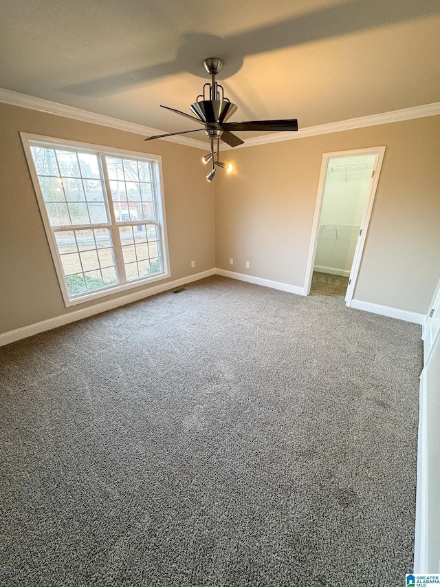 carpeted empty room with ceiling fan and crown molding