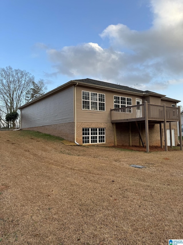 back of house featuring a wooden deck and a lawn