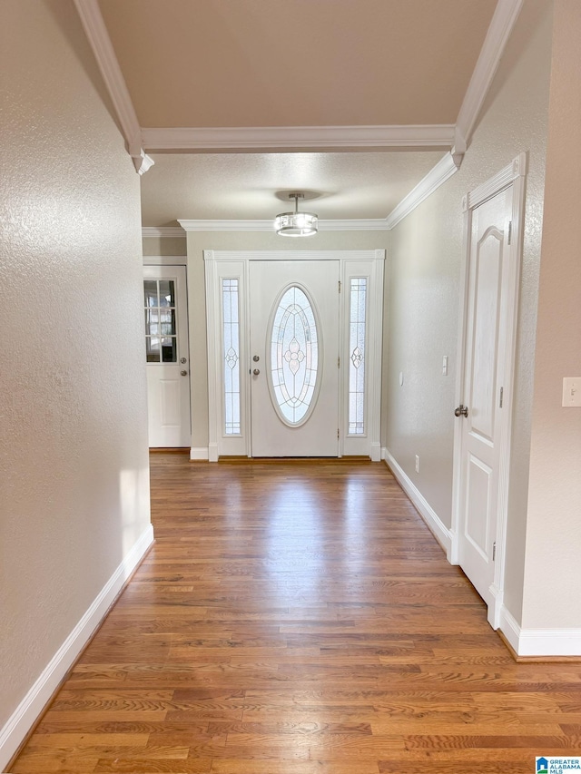 entryway featuring ornamental molding and hardwood / wood-style flooring