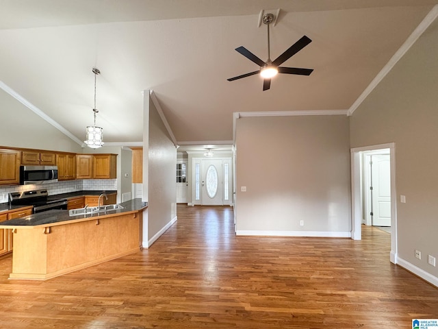 kitchen with kitchen peninsula, stainless steel appliances, tasteful backsplash, a kitchen breakfast bar, and ornamental molding