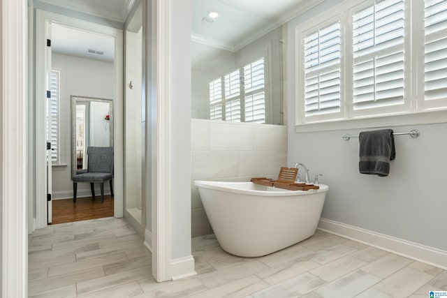 bathroom featuring crown molding and separate shower and tub