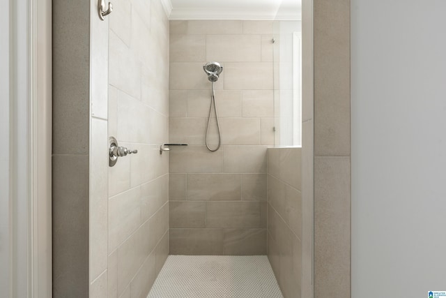 bathroom with a tile shower and crown molding