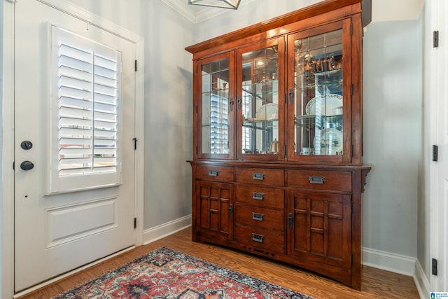 entryway featuring hardwood / wood-style flooring, a wealth of natural light, and ornamental molding