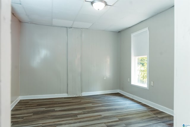 empty room with a paneled ceiling and hardwood / wood-style floors