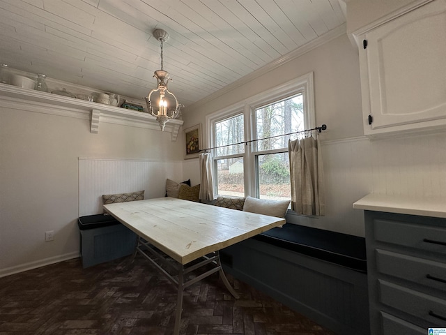 dining space featuring dark parquet floors, wood ceiling, crown molding, and breakfast area