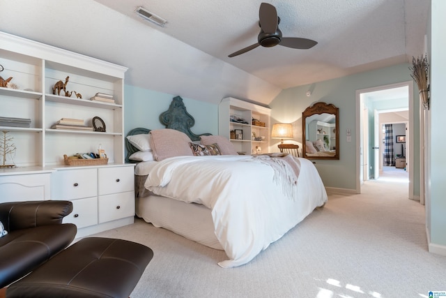 carpeted bedroom featuring vaulted ceiling, ceiling fan, and a textured ceiling